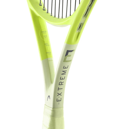 Close-up of a green HEAD Extreme MP 2024 Tennis Racket, highlighting the grip and part of the strings. The word "EXTREME" is printed on the neck and incorporates HEAD Auxetic 2.0 technology for exceptional spin.