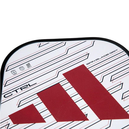 Close-up of the adidas RX CTRL 3.3 Pickleball Paddle with a bold red adidas logo, black "CTRL" text, and a patterned white background featuring black angular lines. "Spin Blade Grit" on the edge offers enhanced control.
