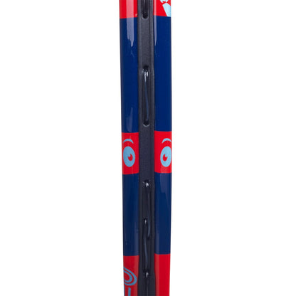 Close-up of a Babolat BallFighter 19 Junior Tennis Racket frame with a vivid blue and red color scheme, highlighted by white eye-like patterns. This kids' tennis racket includes string holes along its side, making it ideal for teaching young players the proper grip.