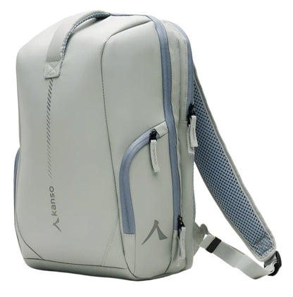 The Kanso Intuko Tennis 23L Backpack in grey offers a sleek, modern design with two zippered front pockets, an adjustable shoulder strap with mesh pad, and a top carry handle. Featuring reflective print and "kanso" on the side, it combines functionality and style for any occasion.