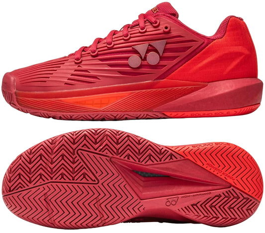 The Yonex Power Cushion Eclipsion 5 Women’s Tennis Shoes in Ruby Red feature textured soles, a geometric side pattern, and a round sole design with the Yonex logo, shown from both side and bottom views.