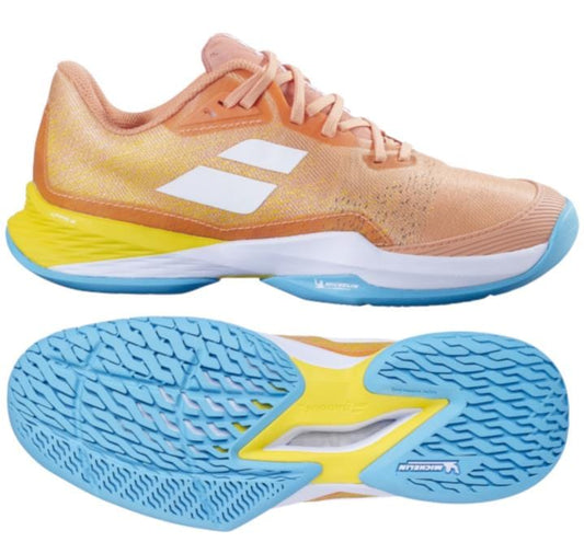 The Babolat Jet Mach 3 2024 Women's Tennis Shoes in Coral and Gold Fusion feature an orange and peach upper with a white logo on the side, bright blue Michelin soles, and a yellow accent on the heel. These shoes incorporate Matryx technology for enhanced grip with a textured sole.