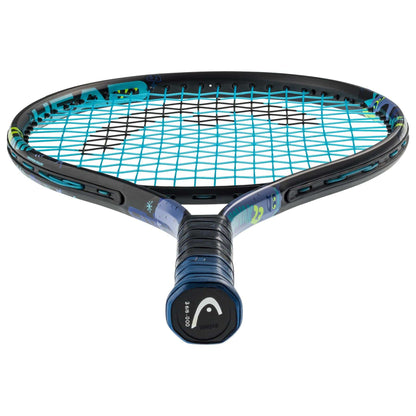 The HEAD Novak 23 Junior Tennis Racket, featuring a black frame with blue strings and a dark blue handle, is displayed. It showcases colorful graphics on the frame and includes a Damp+ insert to minimize vibration. The HEAD brand logo is prominently placed on the butt cap of the handle. This junior racket, angled upwards, emphasizes its distinctive string pattern.
