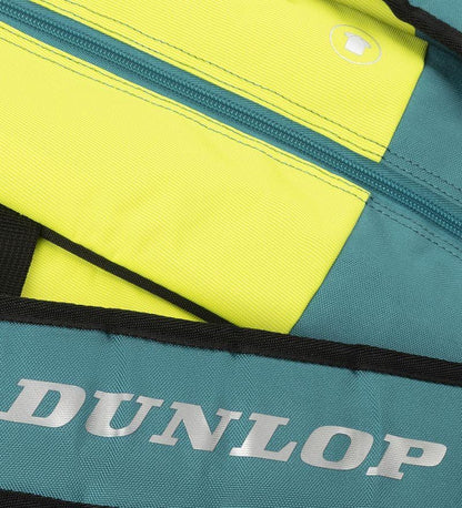 A close-up of the Dunlop SX Performance 12 Racket Tennis Bag in teal, black, and yellow shows a zipper pocket. "Dunlop" is printed in large silver letters on the strap, which features ergonomic shoulder straps for comfort.
