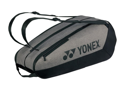 The Yonex 42526EX Team 6 Racket Tennis Bag in grey and black features multiple zippered compartments and adjustable shoulder straps, making it perfect for effortlessly carrying your sports equipment.
