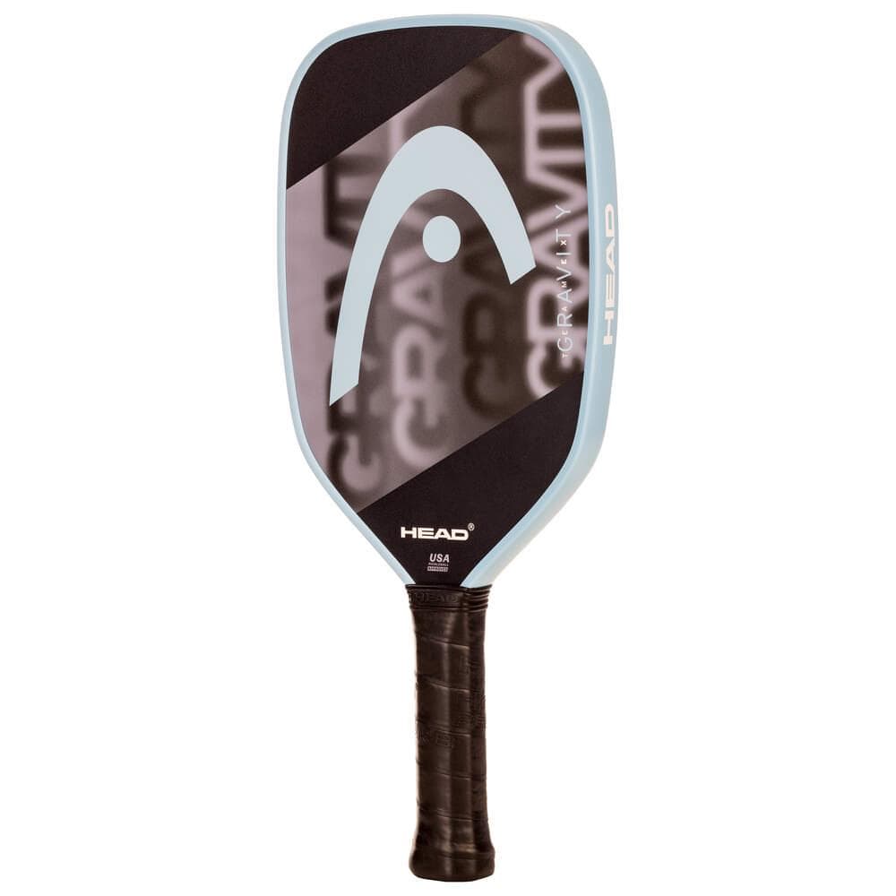 The HEAD Gravity Team EX 2025 Pickleball Paddle features a black face, light blue edge, large HEAD logo, and "GRAVITY" partially visible. It offers excellent control and has a handle wrapped in black grip tape.