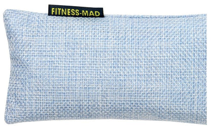 A rectangular eye pillow in blue, crafted with a textured fabric surface and featuring active charcoal deodorizers. It includes a small black tag with yellow text reading "FITNESS-MAD.