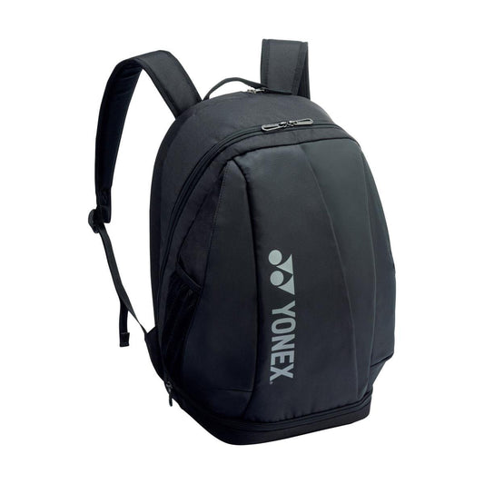 Introducing the Yonex 92412MEX Pro Tennis Backpack in a sleek black design, ideal for athletes on the move. It boasts a curved top with adjustable shoulder straps and offers a spacious main compartment perfect for storing rackets, along with a convenient front zippered pocket. The Yonex logo is prominently displayed on the side for an added touch of style.