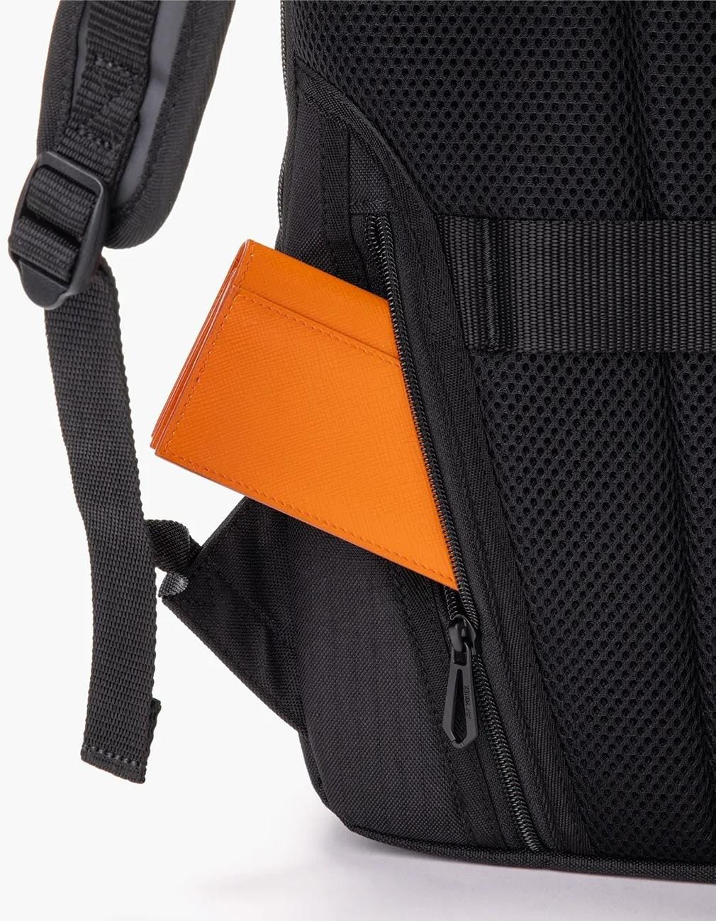 An orange wallet is partially tucked into a zipped side pocket of a beige Yonex BA72612EX Gearlogic tennis backpack with mesh padding and adjustable straps.