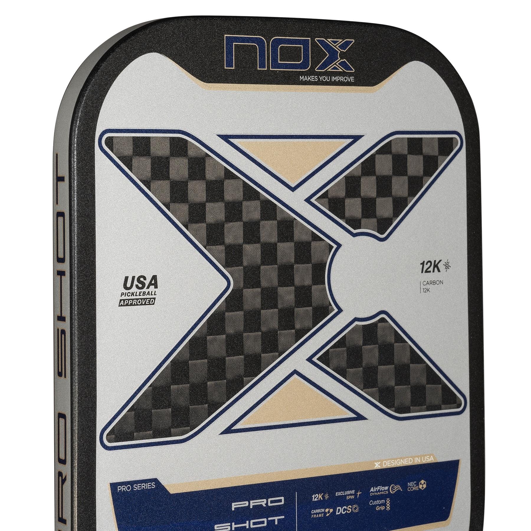 Close-up of the NOX Pro Shot Pickleball Paddle by NOX, showing a bold X design, carbon fiber texture, spin technology features, and “USA Pickleball Approved” text on a silver, black, and blue background.