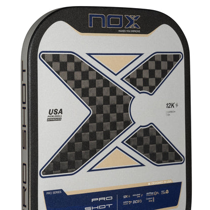 Close-up of the NOX Pro Shot Pickleball Paddle by NOX, showing a bold X design, carbon fiber texture, spin technology features, and “USA Pickleball Approved” text on a silver, black, and blue background.