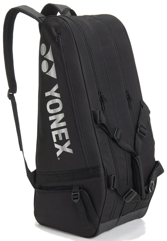 The Yonex BA72626EX Gearlogic 6 Racket Tennis Bag in black features multiple zippered compartments, adjustable shoulder straps, and a white Yonex logo—ideal for sports and organized tennis gear.