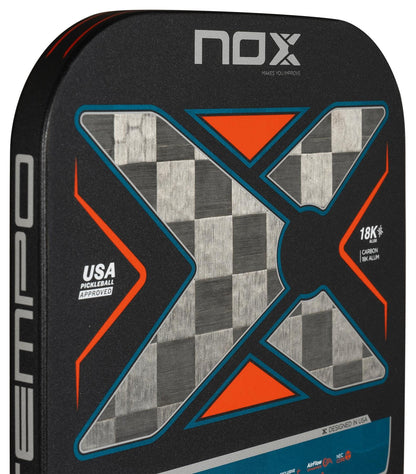 Close-up of the NOX Luxury Tempo Pickleball Paddle by NOX, showing a bold checkered "X" design with orange accents, 18K aluminised carbon fiber, and text including “USA Pickleball Approved” and “Exclusive Spin technology.”.