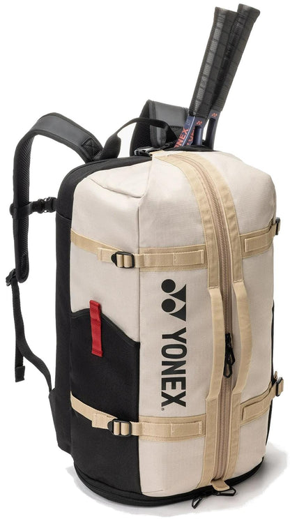 The Yonex BA72612EX Gearlogic Tennis Backpack in beige features a large zipper, external straps, and top compartment for two racquets—an ideal, stylish option for tennis players on the go.