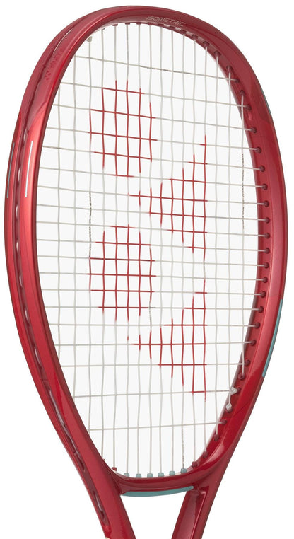 A close-up of the Yonex VCORE 100L Ruby Red 2026 Tennis Racket shows its oval frame and white strings with a red "YY" logo, highlighting this Yonex racket’s impressive spin potential.