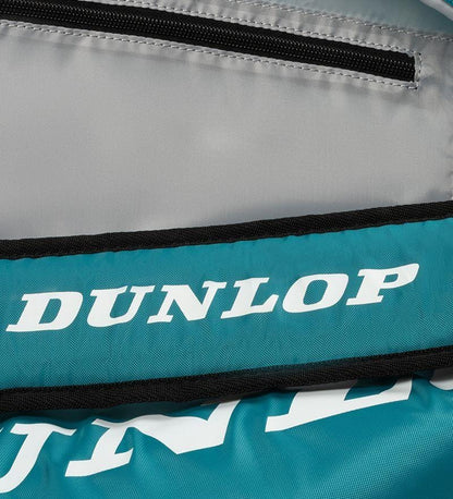 Close-up of a Dunlop SX Club 10 Racket Tennis Bag in teal, black, and yellow. The white Dunlop logo contrasts on the teal area, emphasizing its importance as essential tennis equipment. A partially visible black zipper is at the top.