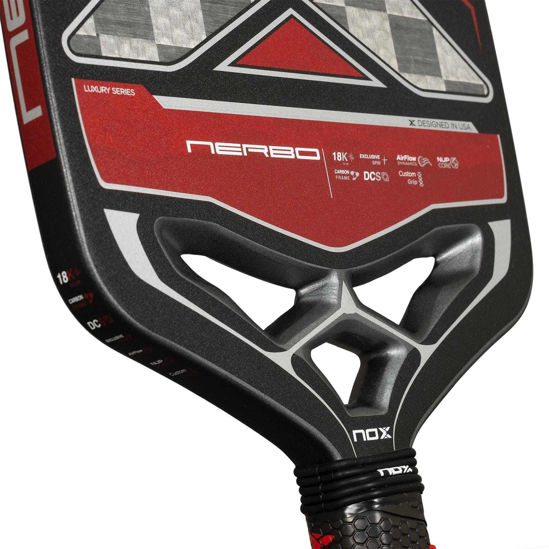 Close-up of the NOX Luxury Nerbo Pickleball Paddle by NOX, showing its red and black design, "NERBO" model name, textured grip, technical details, and geometric cutouts in the throat.