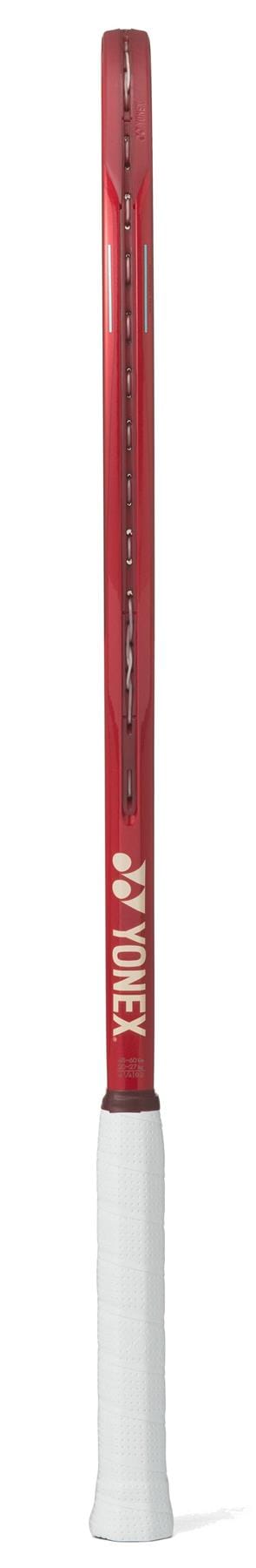 A Yonex VCORE 95 2026 Ruby Red Tennis Racket is shown from the side, featuring a white grip and the "Yonex" logo on the throat, designed to deliver maximum spin on the court.