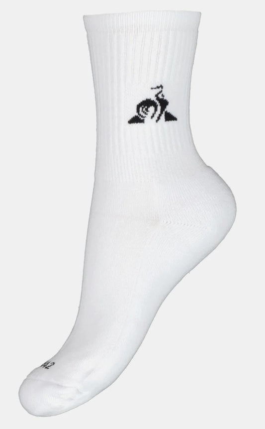 Displayed on a mannequin foot, the Le Coq Sportif Mens Tennis Socks in white feature a black snail logo with a swirl pattern near the top. These socks from Le Coq Sportif boast moisture-wicking technology, ribbed detailing, and a reinforced heel and toe area, making them perfect for tennis enthusiasts.