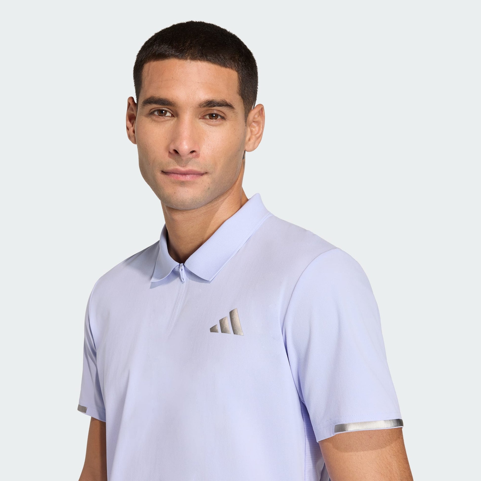 A man in an adidas Climacool Mens Tennis Polo Shirt in Violet Tone stands against a plain light background, facing the camera with a neutral expression.