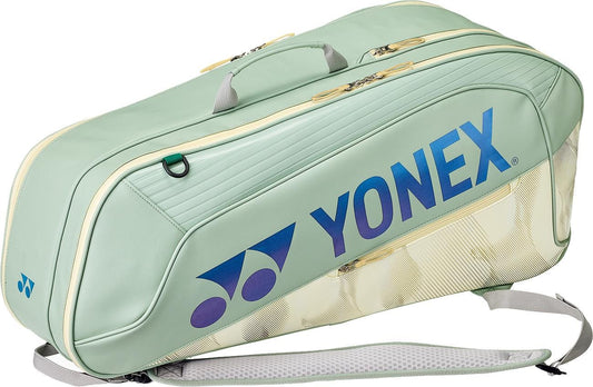 The Yonex 02626EX Expert 6 Racket Tennis Bag in smoke green features the Yonex logo and name in blue, a handle, shoulder strap, multiple zippered compartments, and dedicated racket storage to keep your gear organized.