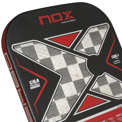 Close-up of the NOX Luxury Nerbo Pickleball Paddle by NOX, showcasing a checkered gray "X" design, red accents, "USA Pickleball Approved" text, and "18K Carbon Fiber" highlighted on its surface.