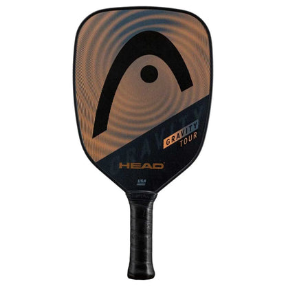 The HEAD Gravity Tour 2023 Pickleball Paddle by HEAD features a black and copper design, large logo, and black handle. Its Hybrid Hitting Surface and SpinOn tech boost control and spin, with "Gravity Tour" and "HEAD" on the face.