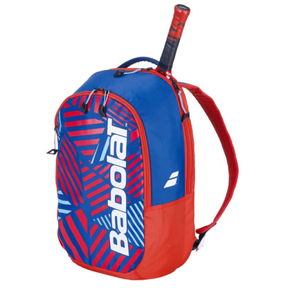 Discover the Babolat Kids Tennis Backpack in Blue/Red, with a bold geometric pattern. Made from recycled materials, it has a racket compartment with handle visibility and prominently features the iconic Babolat logo on the front.