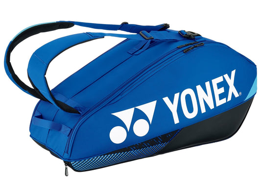 A Yonex 92426EX Pro 6 Racket Tennis Bag in cobalt blue, featuring the Yonex logo in white. It includes multiple zippered compartments and adjustable black straps, perfect for carrying sports equipment. The tennis bag is displayed against a plain white background.