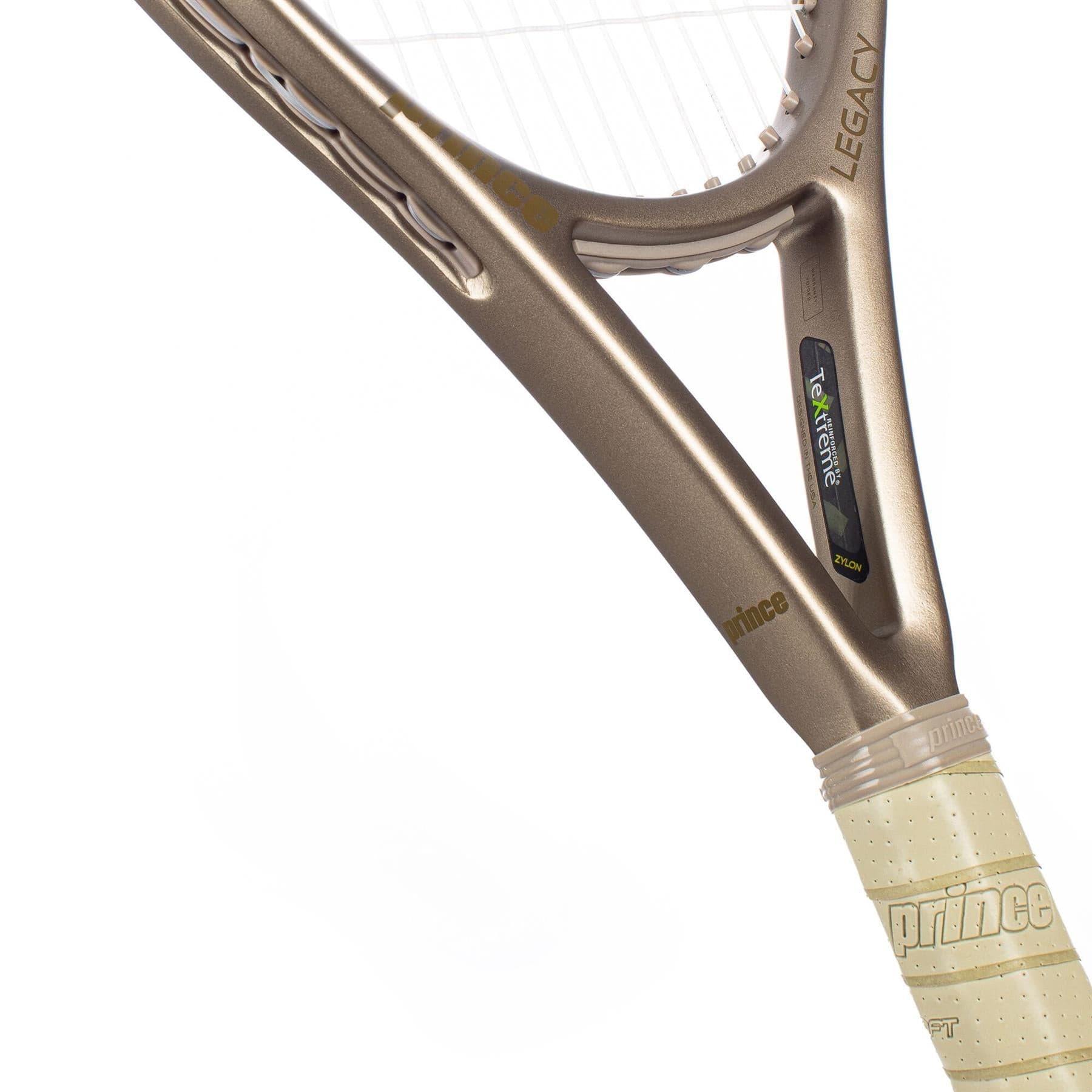 Close-up of the throat and handle of a metallic gold Prince O3 Legacy 120 2025 Tennis Racket with a cream grip. "Legacy" and "Textreme" on the frame highlight TeXtreme technology for an enlarged sweetspot. Plain white background.