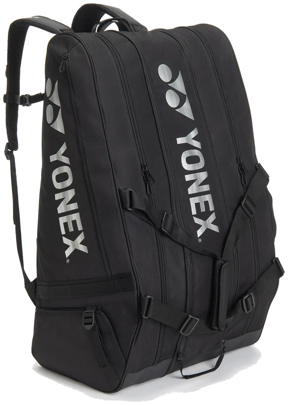 The Yonex BA726212EX Gearlogic 12 Racket Tennis Bag in black has three zippered compartments, sturdy shoulder straps, and a white Yonex logo—ideal for carrying sports gear or as a compact tennis bag.