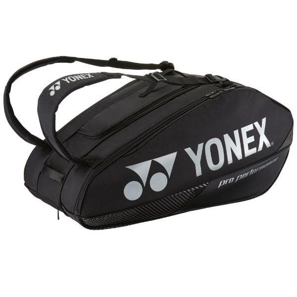 The Yonex 92429EX 9 Racket Pro Tennis Bag in black, designed by Yonex, offers multiple compartments and durable YKK zippers. It features shoulder straps along with the Yonex logo and "Pro Performance" text in white. Its Thermo Guard lining guarantees optimal protection for your gear.