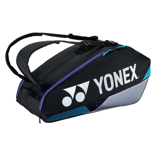 The Yonex 92426EX 6 Racket Pro Tennis Bag in Black/Silver features a sleek design with the signature Yonex logo, adjustable shoulder straps, and subtle blue accents. It offers a spacious compartment for sports equipment, along with a dedicated shoe compartment, making it perfect for tennis enthusiasts on the move.