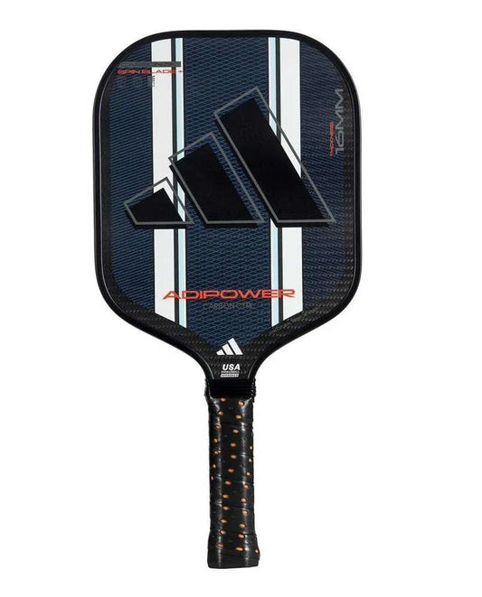 The adidas ADIDAS Adipower Carbon CTRL 3.3 Pickleball Paddle is black with white stripes, an orange-accented perforated grip, a large Adidas logo, and 3K carbon construction. Features branding and USA Pickleball approval markings.
