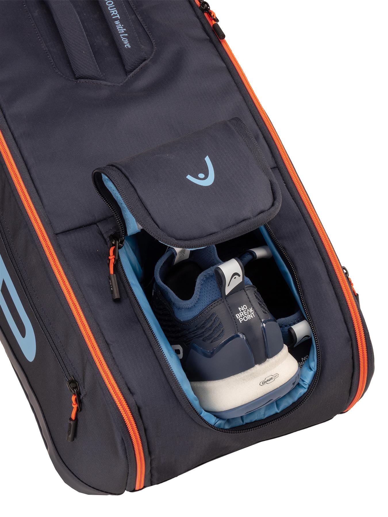 A close-up of the HEAD Pro 9 Racket Tennis Bag L - Navy by HEAD, featuring orange zippers and an open compartment with blue and white athletic shoes partially visible inside.