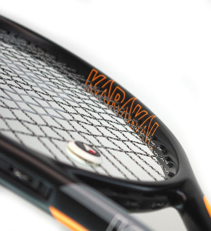 Close-up of a Karakal Graphite Pro 280 tennis racket showcasing a black frame and tightly woven strings. The "Karakal" brand name is prominently displayed on the side, while the Fast Fibre Nano Graphite Gel technology provides added strength. Yellow accents enhance this lightweight racket's dynamic appearance.